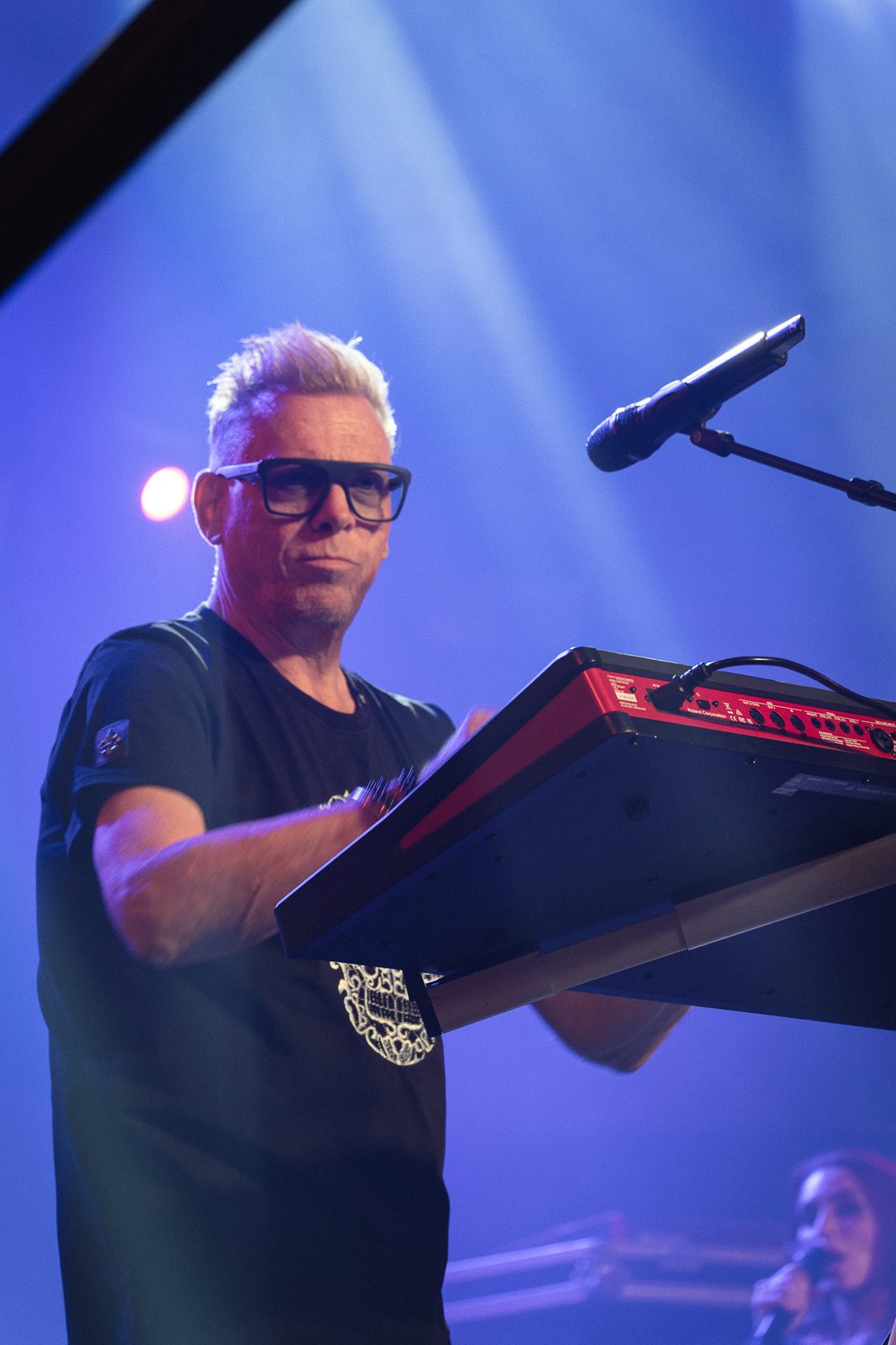 Musician performing under vivid blue stage lights